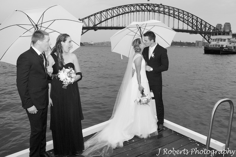 Bridal couple kissing and attendants looking shocked - wedding photography sydney